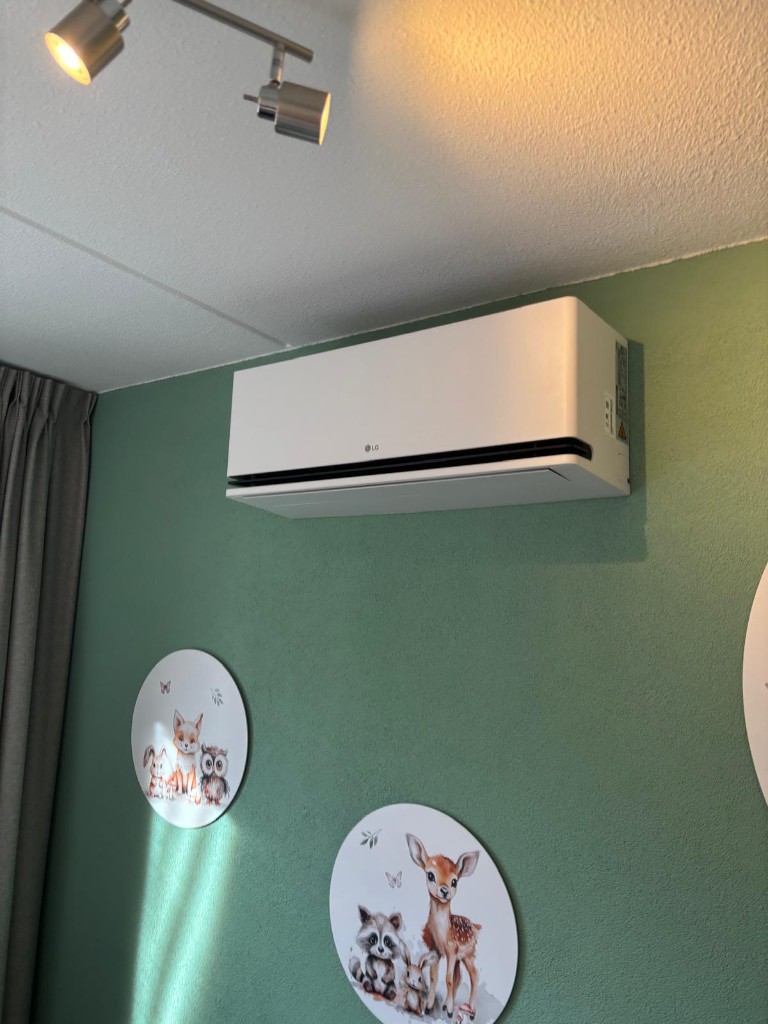 Witte LG binnendeel gemonteerd op een groene wand