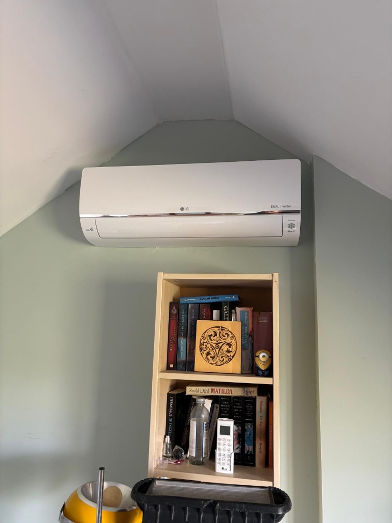 LG Dual Inverter binnendeel bij een boekenkast onder een schuin plafond
